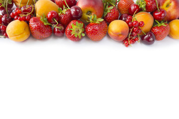 Various fresh summer berries. Top view. Ripe strawberries, redcurrants, apricots, nectarines and cherries on white background. Berries at border of image with copy space for text. Background berries.