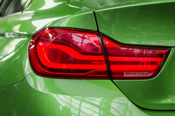 Close-up sports car rear tail-lamp with brakelight stop signal
