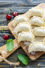 Dumplings with cherries on floured board.