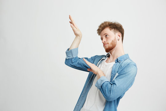 Young Positive Handsome Man In Headphones Listening To Music Dancing Moving Over White Background.