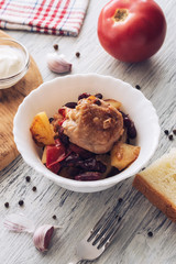 Braised chicken and beans in a plate on the table.