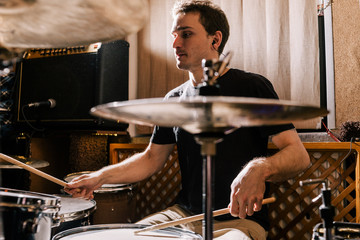 Drummer rehearsing on drums before rock concert. Man recording music on drum set in studio