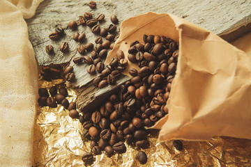 Close up roasted coffee beans in paper bags on wooden background