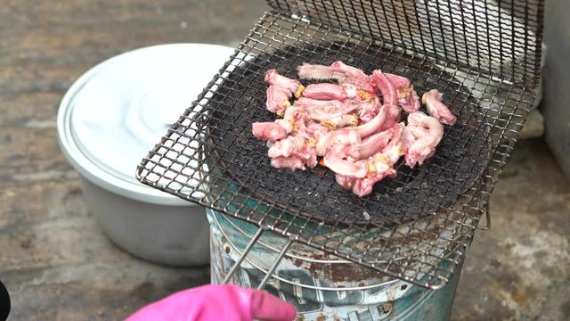 4K South Korean restaurant prepping inshore hagfish for grilling, after remove the skin off a live eel put on BBQ grill. Chef cooked kkomjangeo, grilled food at Jagalchi Fish Market Busan-Dan