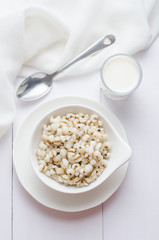 Healthy breakfast with boiled job's tears porridge in white bowl on wooden table.