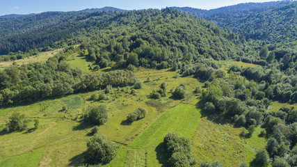  a beautiful summer landscape shot from a bird's eye view. mountains, river, green fields and villages.