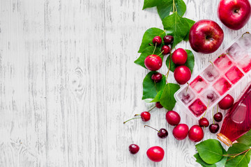 Apple, pulm, cherry, ice for summer fruit drink on wooden table background top view copyspace