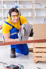 Repairman carpenter cutting sawing a wooden plank with a circula