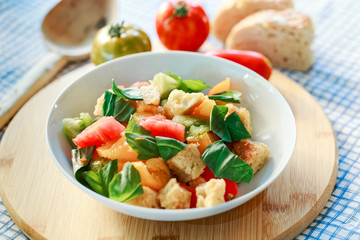 Bunter Tomaten Brot Salat mit Basilikum in weisser Schale