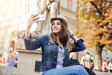 Obraz na płótnie Canvas Beautiful tourist girl taking a selfie in european city, travelling around the globe seeking adventures.