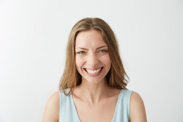 Beautiful sincere happy girl smiling laughing looking at camera over white background.