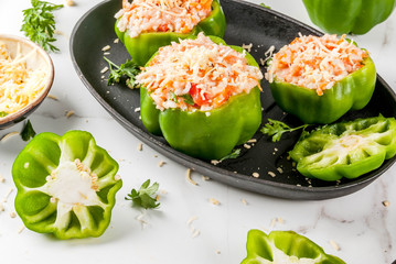 Autumn recipes. Home stuffed bell pepper with minced meat, carrots, tomatoes, herbs, cheese. Cooking process. White marble table. Stuffed pepper ready for baking, in pan, Copy space