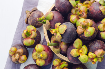 Fresh mangosteen fruits in the basket on paper background.