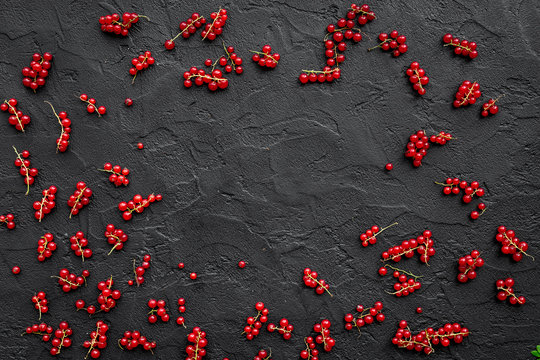 Berry frame. Red currant on black table background top view copyspace