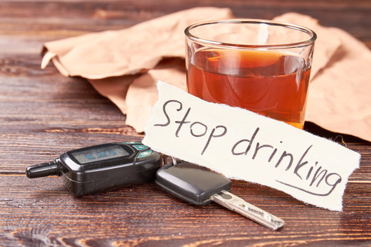 Automobile keys, message, glass of alcohol. Message stop drinking, car keys, glass of alcohol beverage. Stop drinking and obey the law.