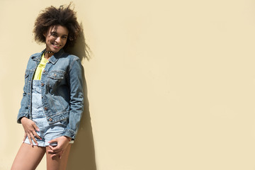 Positive hipster girl is standing outdoors