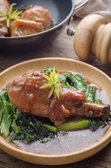 Baked chicken leg with vegetables and sauce on rustic wooden background