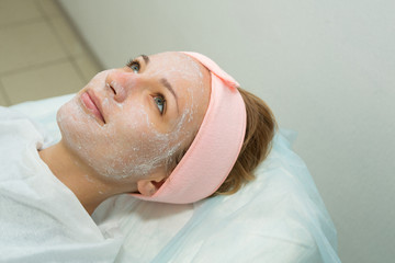 Beautiful young girl on facial cleansing procedure at a cosmetologist