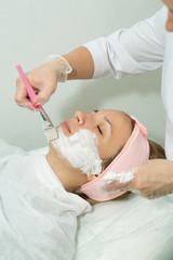Beautiful young girl on facial cleansing procedure at a cosmetologist
