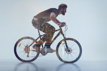 Naklejka premium Aspirated guy with beard cycling in urban place