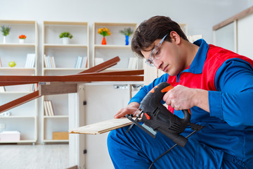 Young carpenter working with wooden planks