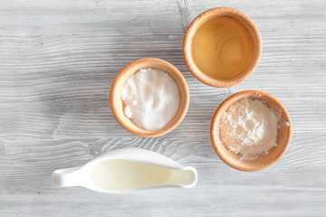 Put the dough. Flour, salt, mik, oil, rolling pin on light wooden table background top view copyspace