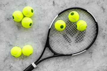 Sport background. Tennis balls and racket on grey background top view