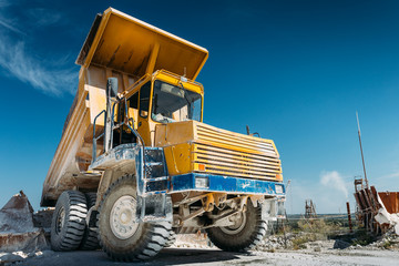 Big yellow mining truck vehicle, truck unloads mined ore or chalk or limestone. Mining industry concept