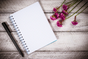 flowers on wooden table. copy space. workspace with notebook. celebration template concept.