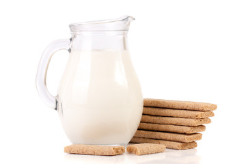 jug of milk with stack of grain crispbreads isolated on white background