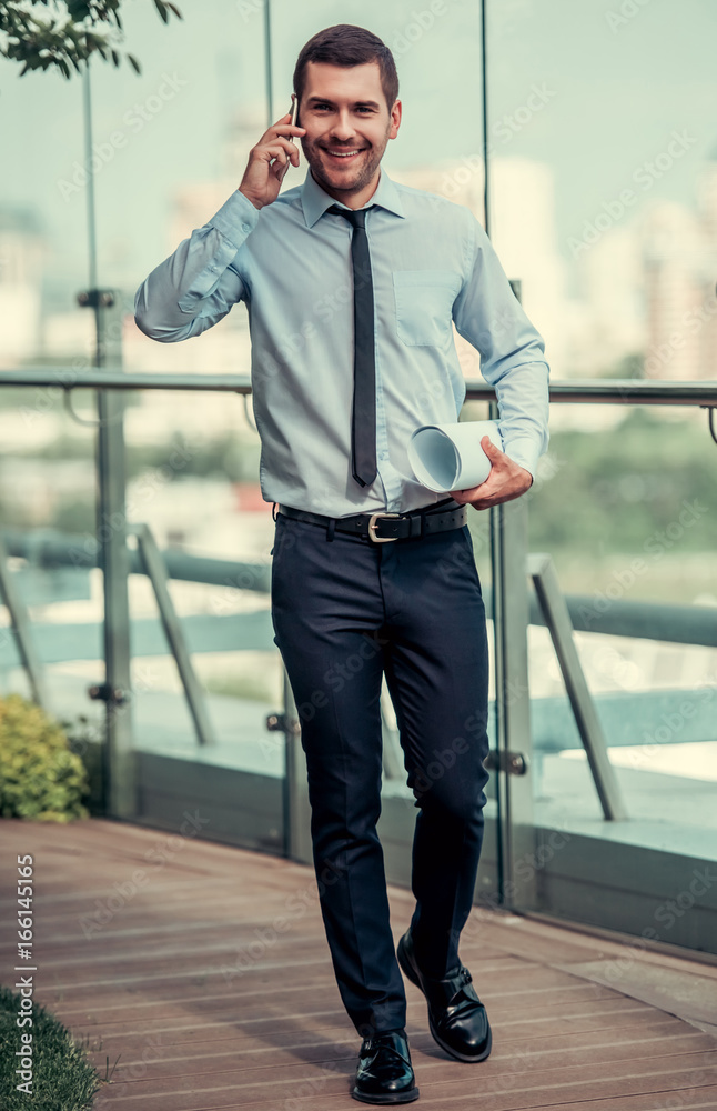 Wall mural Businessman walking outdoors