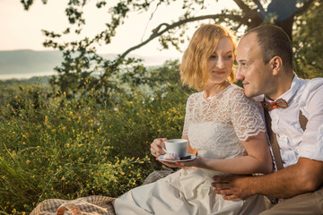 Attractive Couple Enjoying Romantic Sunset Picnic in the Countryside