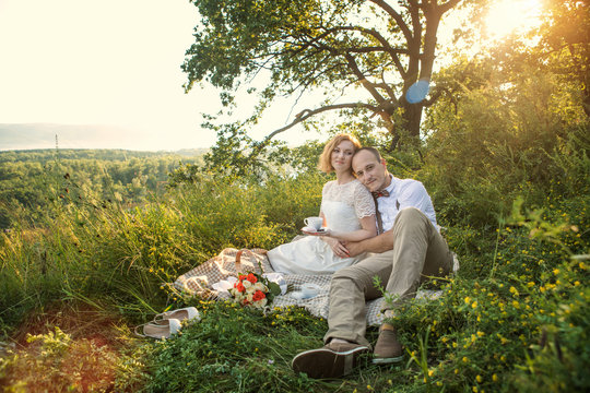 Attractive Couple Enjoying Romantic Sunset Picnic in the Countryside