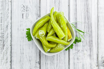 Green Chilis (filled with cheese) on wooden background (selective focus)