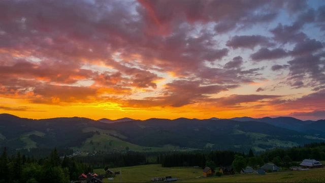 Fantastic Mountain Landscape with Clouds, Village and Forest at Sunrise. Timelapse. 4K.
