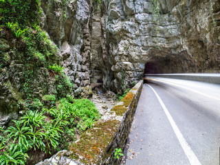 Car rushing along a one way road through a Canyon