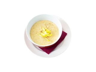 Healthy breakfast. Oatmeal porridge with pieces of a green apple in a white and red  plate. Oatmeal isolated on white background. Purple paper napkin