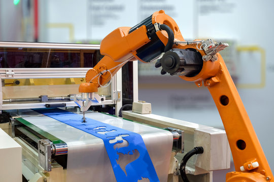 Industrial robot griping workpiece via conveyor belt on smart factory
