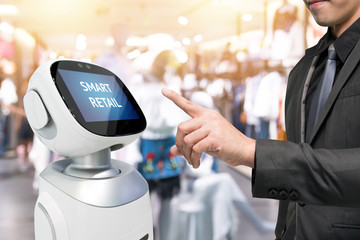 Smart retail sales and crm robot assistant or adviser technology concept. Man Hand suit using robo-advisor display text on screen with blur shopping fashion mall background. Flare light effect.