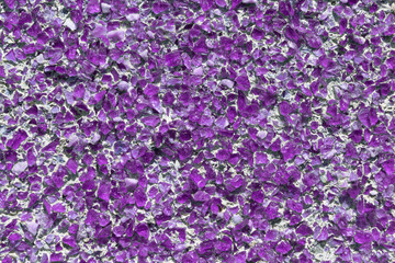 Fototapeta premium Part of the wall covered with small pieces of pink glass or quartz.