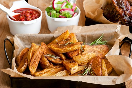 Een plaat van heerlijke pittige gemarineerd gegrild of gebarbecued ribben geserveerd met frietjes en salade op de snackbar of restaurant