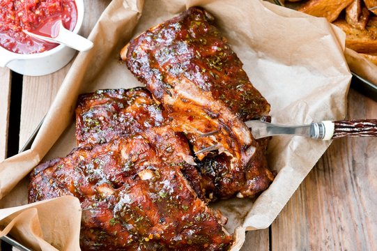 Een plaat van heerlijke pittige gemarineerd gegrild of gebarbecued ribben geserveerd met frietjes en salade op de snackbar of restaurant