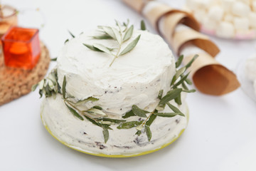 Cake for Wedding or Birthday party. White rustic cake with fresh olive branches