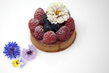 Raspberry and blueberry tart with edible flowers