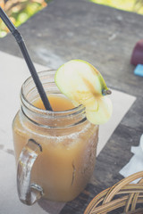 Close up of cold and fresh made apple juice in cafe of Bali island, Indonesia. Healthy drink in the glass. Sweet, delicious diet drink concept.