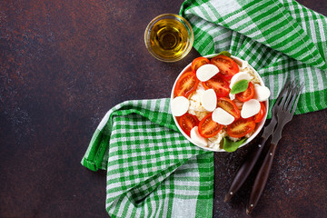 Fresh cabbage salad, tomatoes and cheese against a dark background. Selective focus. Top view. Copy space