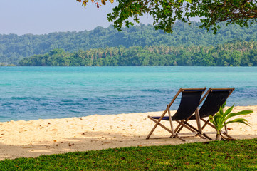 Deckchairs on the tranquil sandy beach at Velit Bay - Espiritu Santo, Vanuatu