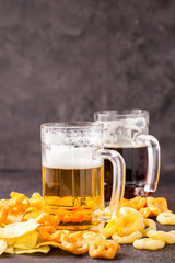 Dark and Light Beer and Snacks against a dark background. Selective Focus. Copy Space