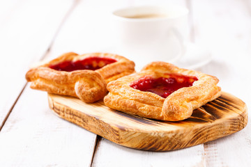 Berry pies and coffee in a cup on a white wooden background. Selective focus.