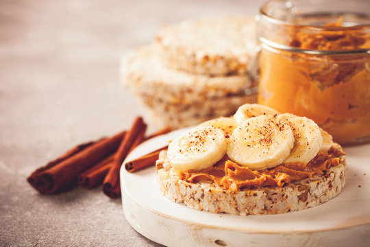 Crisp bread with peanut butter and bananas on a board. Selective focus. Copy space. Image is tinted